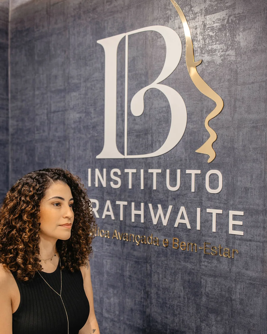 Dra. Ana Clara Brathwaite diante do painel com a logo do Instituto Brathwaite